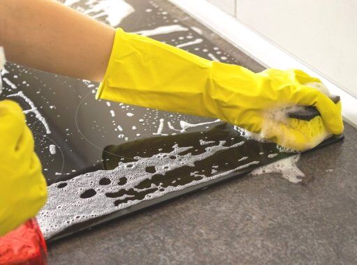 woman-yellow-rubber-glove-cleaning-stove-kitchen-banner-photo.jpg